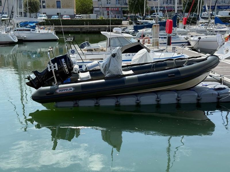 Inflatable boat lifted out of the water on a drive-on dock