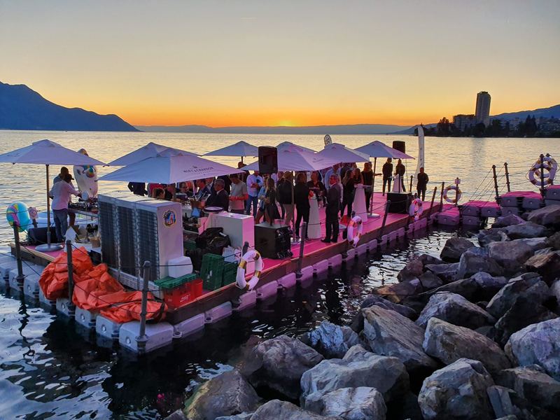 Floating event deck with guests at sunset
