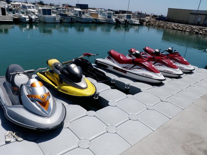Row of jet skis on a grey drive-on dock
