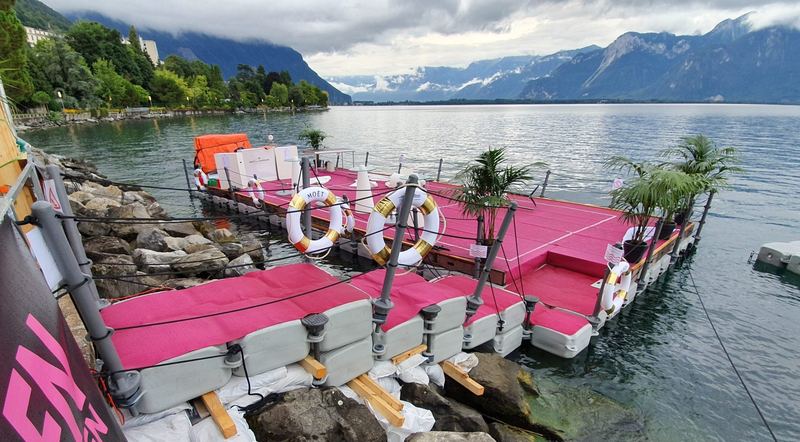 Pink lounge platform with seating on a lake
