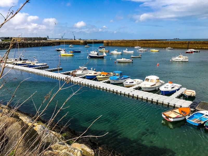 Long floating pontoon lined with small boats