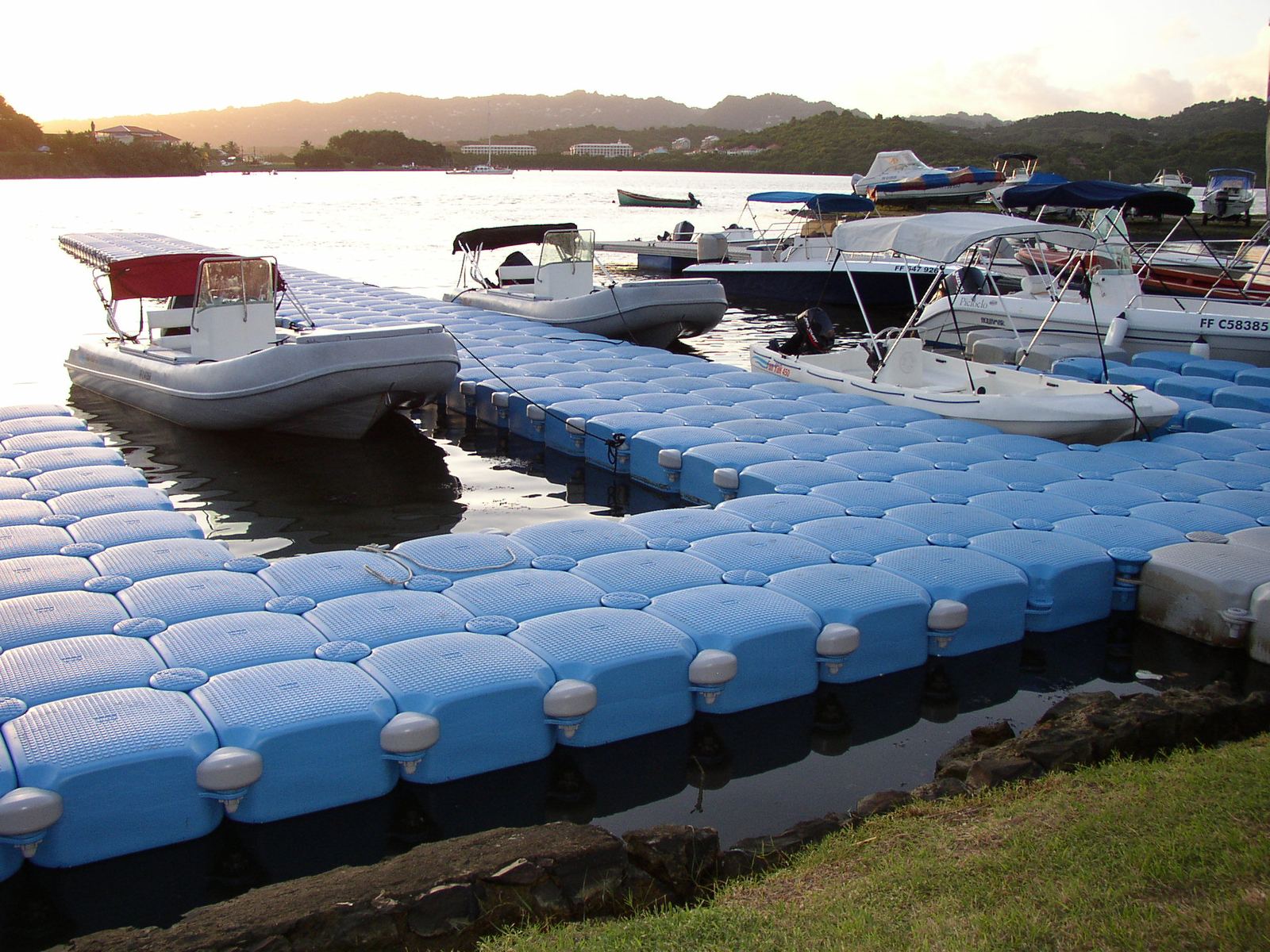 Light blue Cubisystem marina pontoons with moored boats in Martinique