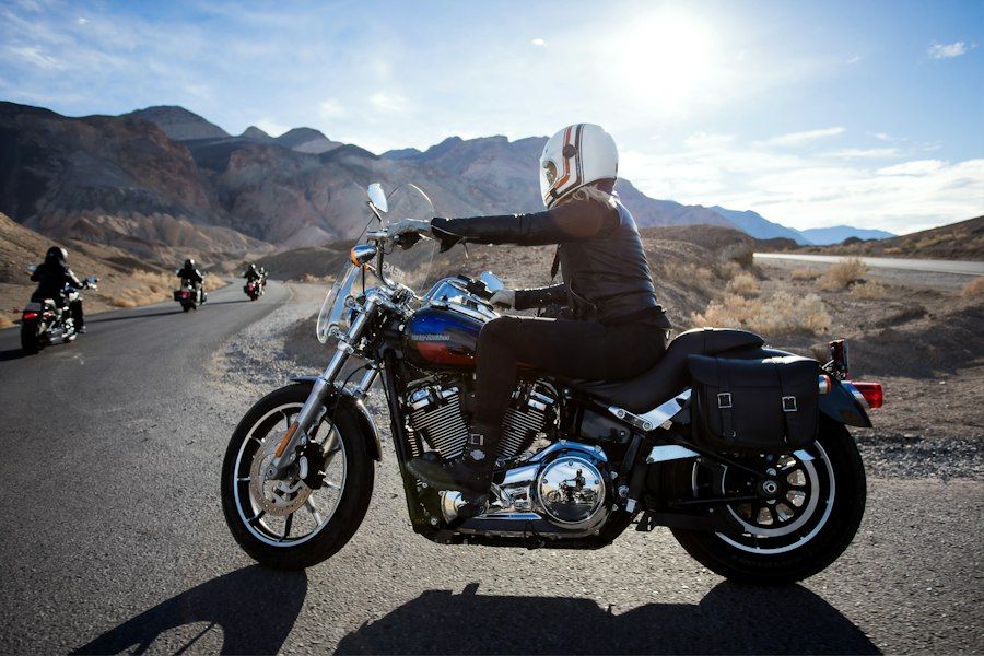 Rider in a white helmet on a cruiser motorcycle on a desert road