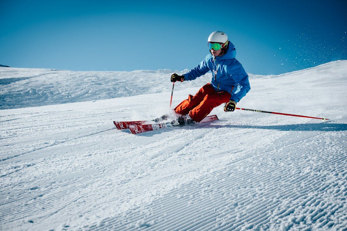 Skier carving down a groomed slope